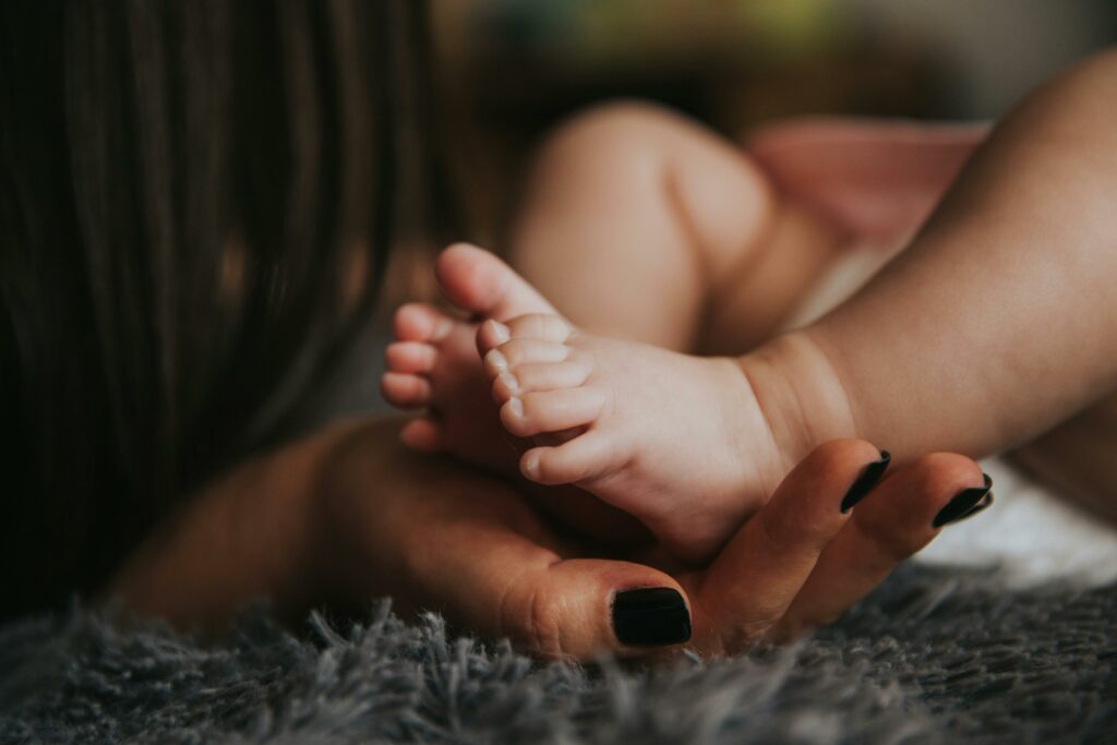 infant feet held in hands