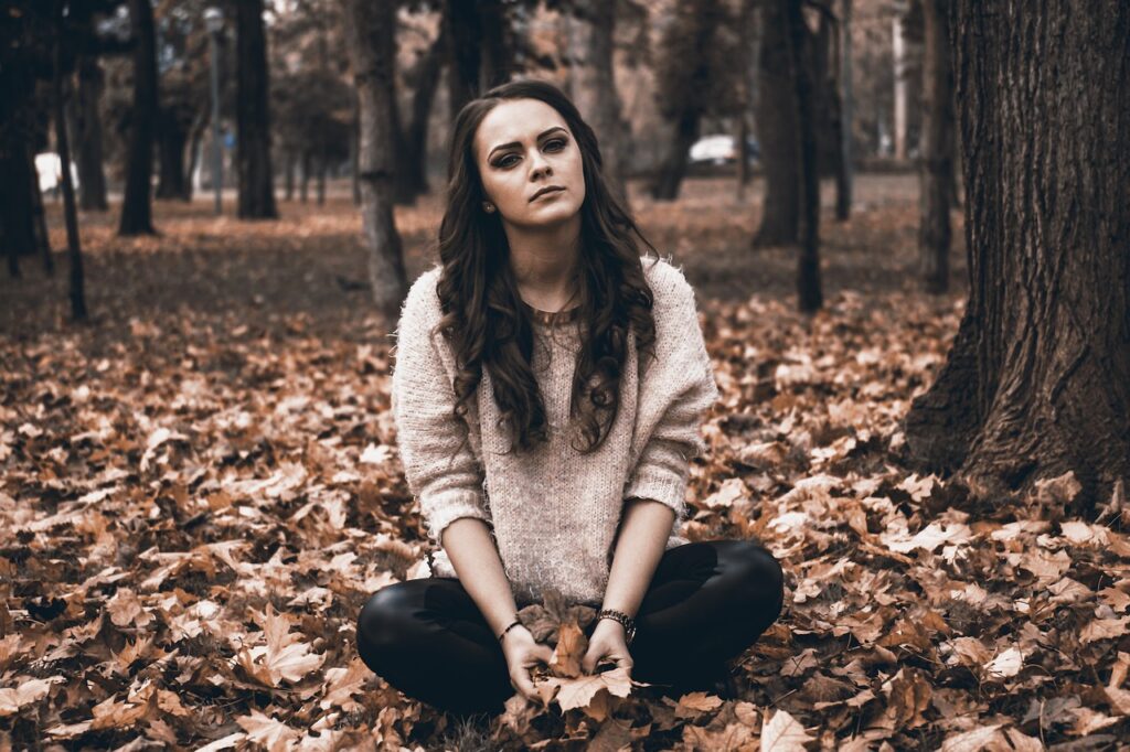 sad young woman in the woods